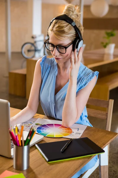 Diseñador gráfico escuchando auriculares —  Fotos de Stock