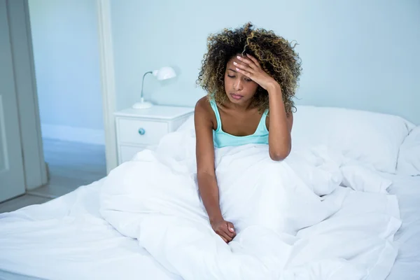 Angespannte Frau auf Bett im Schlafzimmer — Stockfoto