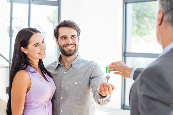 Agente imobiliário dando chaves para casal — Fotografia de Stock