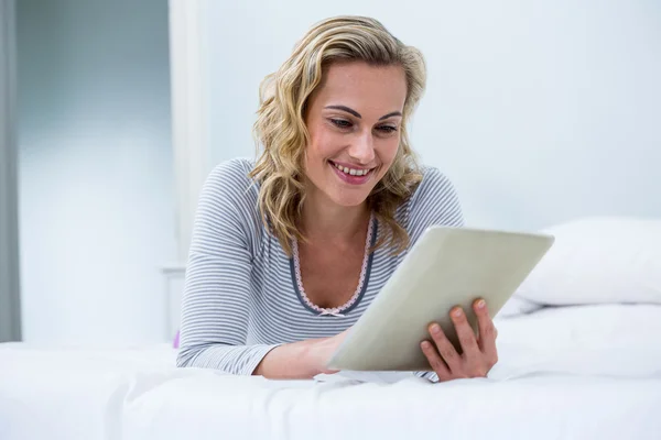 Frau mit digitalem Tablet im Bett — Stockfoto