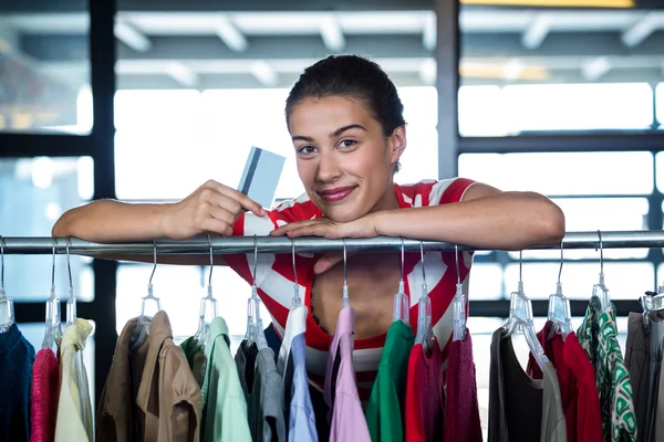 Жінка показує кредитну картку під час покупок — стокове фото