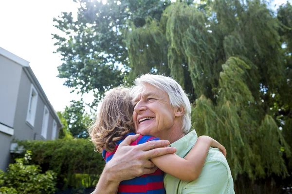 Grandfather hugging grandson at yard — Stock Photo, Image