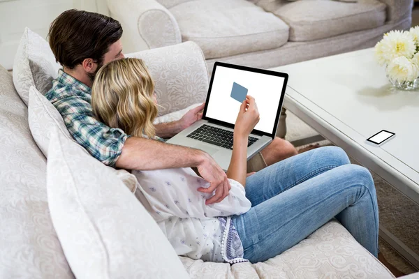 Пара покупок онлайн на диване — стоковое фото