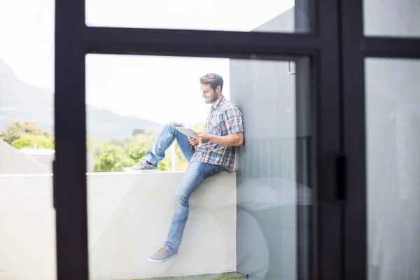Чоловік сидить на терасі за допомогою планшета — стокове фото