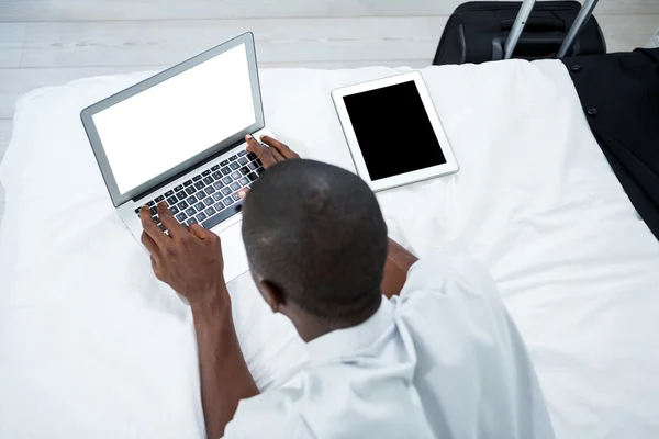 Muž ležel na posteli a přes notebook — Stock fotografie