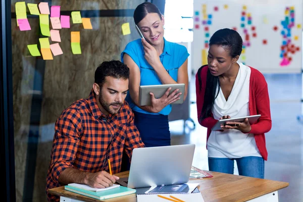 Colleagues interact using tablet, laptop — Stock Photo, Image