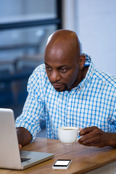 Mann benutzt Laptop beim Kaffeetrinken — Stockfoto