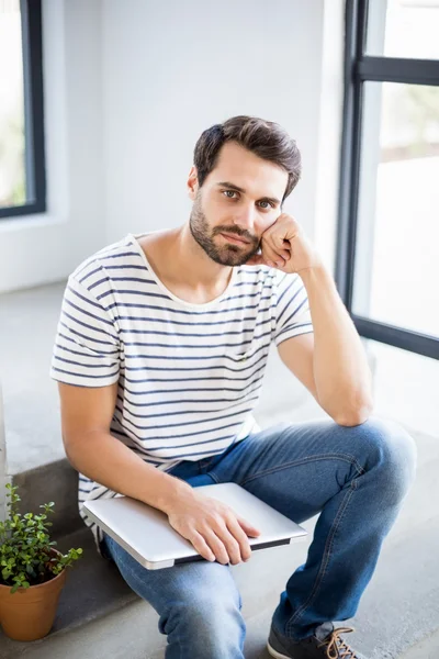 Hombre reflexivo en los pasos con el ordenador portátil — Foto de Stock