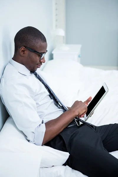 Man using tablet on bed — Stock Photo, Image