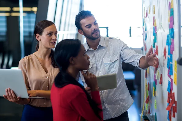 Team of colleagues standing by board — Stock Photo, Image