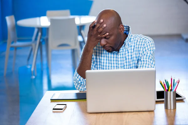 Hombre tenso sentado en la mesa — Foto de Stock