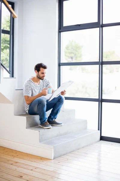 Man on steps having coffee — Stock Photo, Image