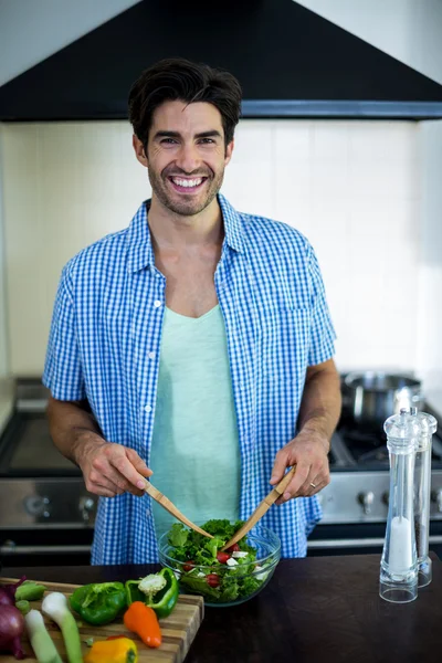Man mixing salad in kitchen — Stock Photo, Image