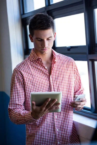 Homem usando tablet e telefone — Fotografia de Stock