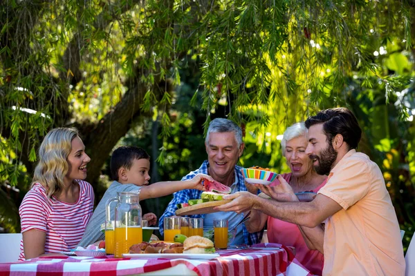 Familia disfrutando mientras come — Foto de Stock