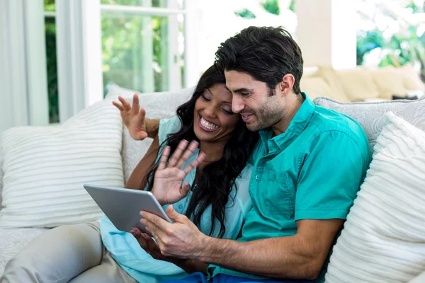 Casal acenando as mãos usando tablet — Fotografia de Stock