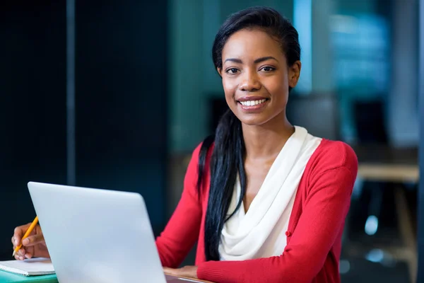 Mujer joven sentada en su escritorio —  Fotos de Stock