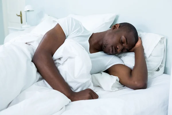 Молодой человек лежит на кровати — стоковое фото