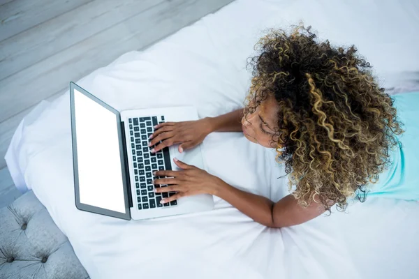 Mujer usando portátil en la cama —  Fotos de Stock