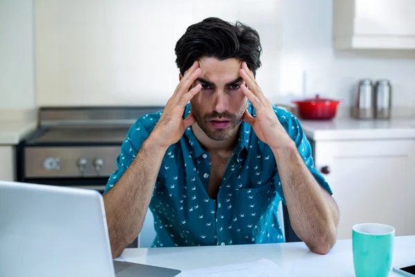 Angespannter Mann mit Scheinen und Laptop — Stockfoto