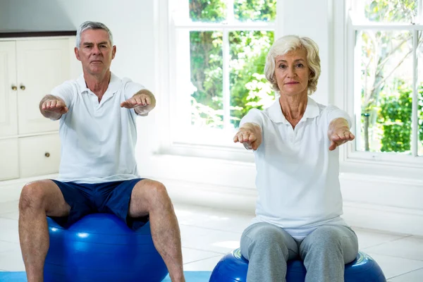 Pareja de ancianos haciendo ejercicio en la pelota — Foto de Stock
