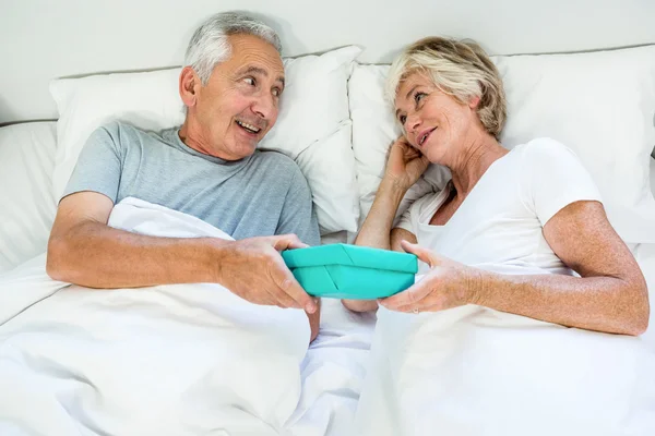 Senior man gifting to woman — Stock Photo, Image