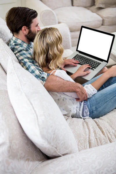 Para za pomocą laptopa na kanapie — Zdjęcie stockowe