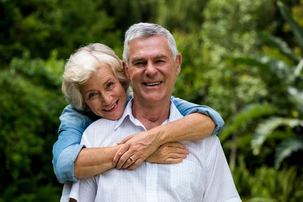 Senior woman embracing husband — Stock Photo, Image