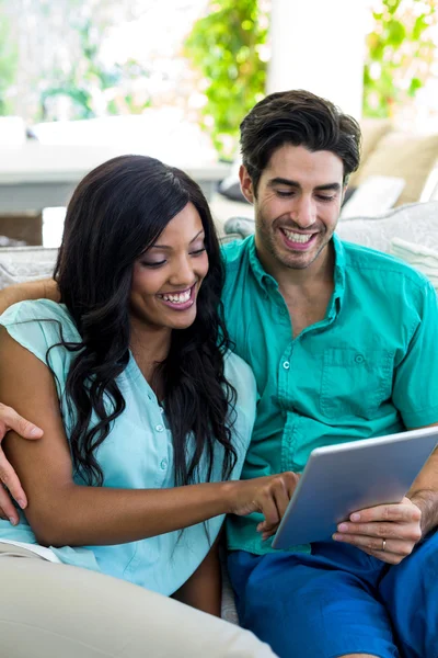 Paret sitter på soffan använder tablet — Stockfoto