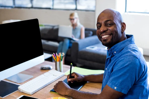 Mann sitzt an seinem Schreibtisch — Stockfoto