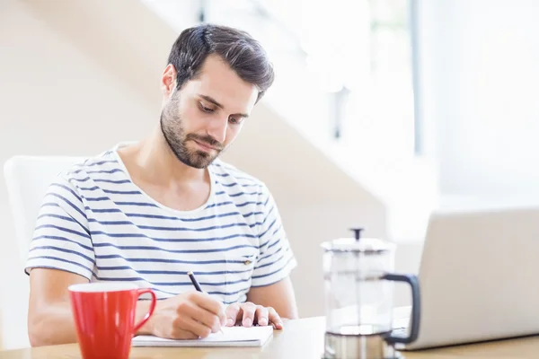 Hombre escribiendo nota en bloc de notas — Foto de Stock