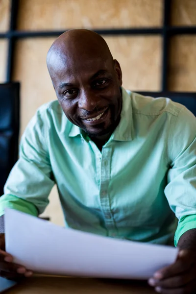 Homem segurando documento sorrindo — Fotografia de Stock