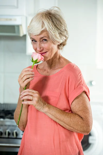 Усміхнена жінка пахне трояндою — стокове фото