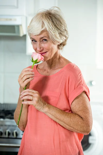 Mujer sonriente oliendo rosa — Foto de Stock