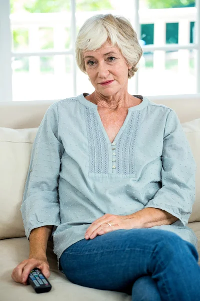 Zamyšleně starší žena na pohovce — Stock fotografie