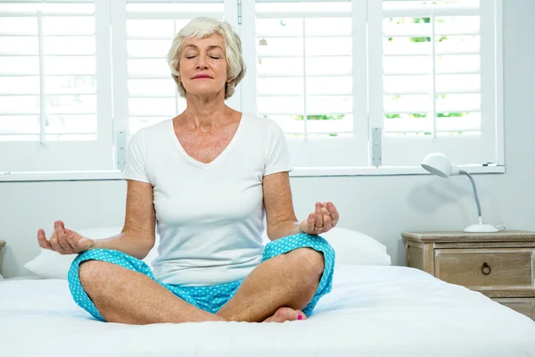 Seniorin macht Yoga im Bett — Stockfoto