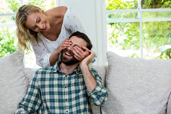 Mulher alegre fechando os olhos do marido — Fotografia de Stock