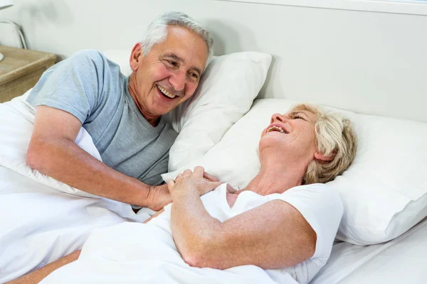 Lachende senior paar op bed — Stockfoto