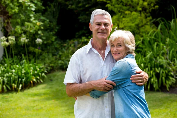 Пожилая пара обнимается на заднем дворе — стоковое фото