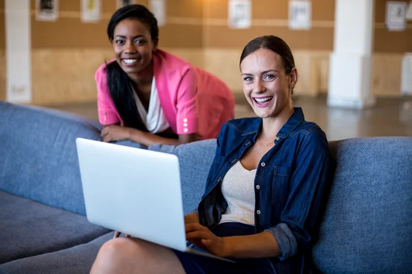 Colleagues sitting on sofa smiling — Stock Photo, Image