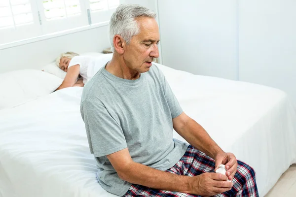 Старший мужчина сидит на кровати — стоковое фото