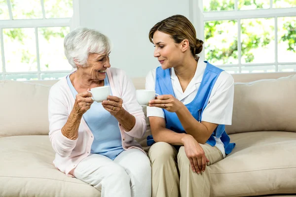 Nurse and woman holding coffee cups — Stock Photo, Image