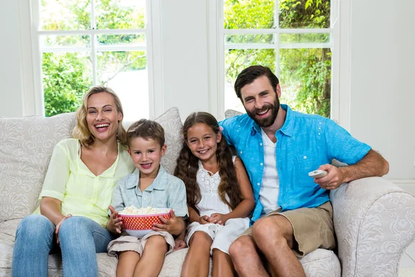 Familia riendo mientras mira la televisión —  Fotos de Stock