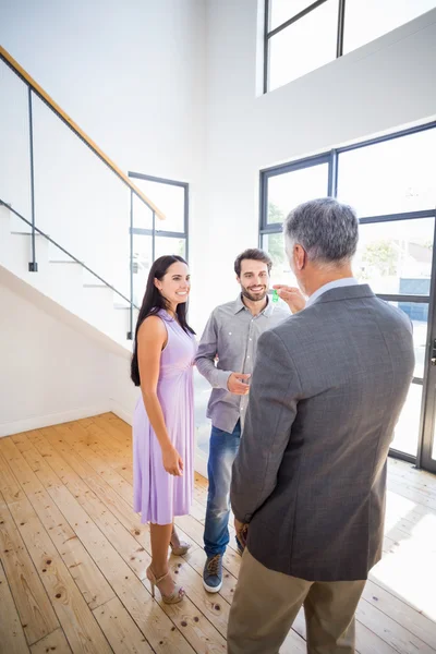 Agent übergibt Schlüssel an Paar — Stockfoto