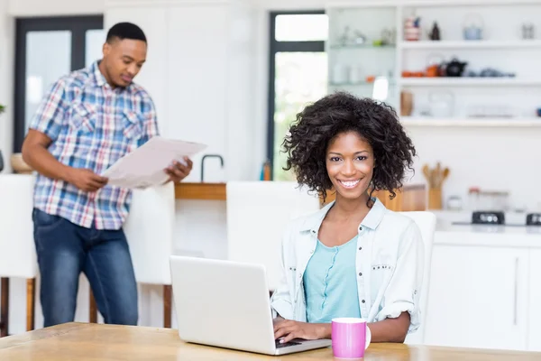 Mulher usando laptop na cozinha — Fotografia de Stock