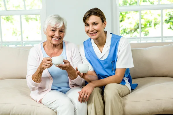 Infermiera sorridente con donna anziana — Foto Stock