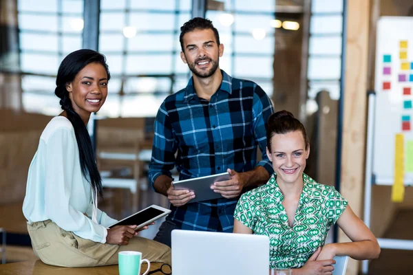 Hombres y mujeres sentados en el escritorio — Foto de Stock