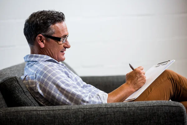 Man schrijven opmerking op Klembord — Stockfoto