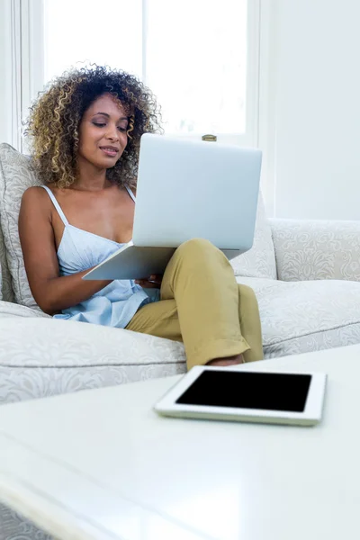 Mujer en el sofá y el uso de ordenador portátil —  Fotos de Stock