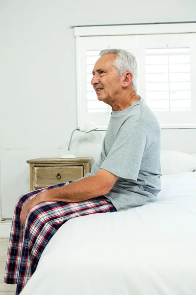 Старший мужчина на кровати дома — стоковое фото